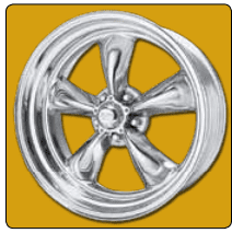 Chrome car wheel rim on yellow background.